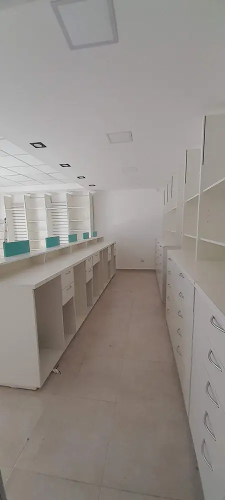 Equipamiento comercial a medida para farmacia con mostradores, cajoneras y estanterías