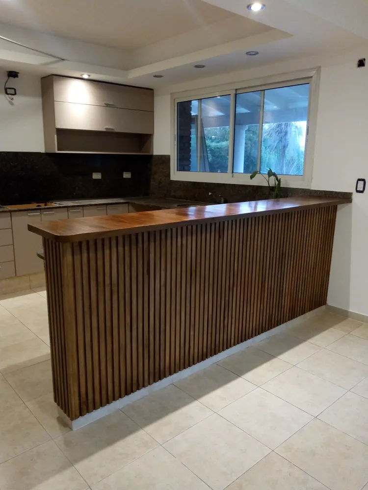 Cocina a medida con barra de madera listonada